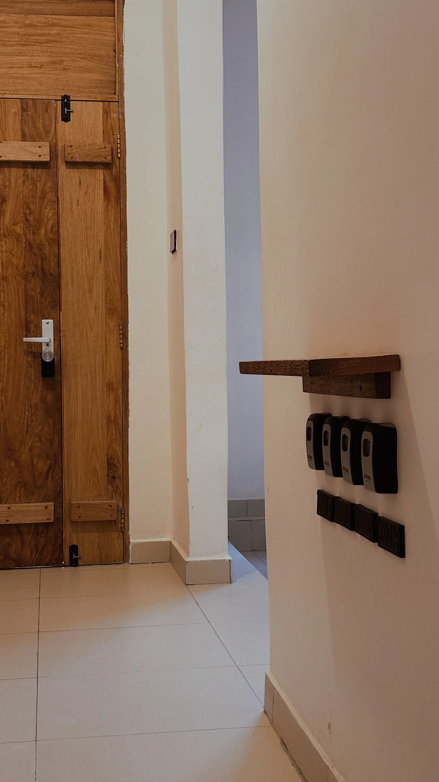 Flur mit hölzerner Zimmertür und Schlüsselkästen an der Wand