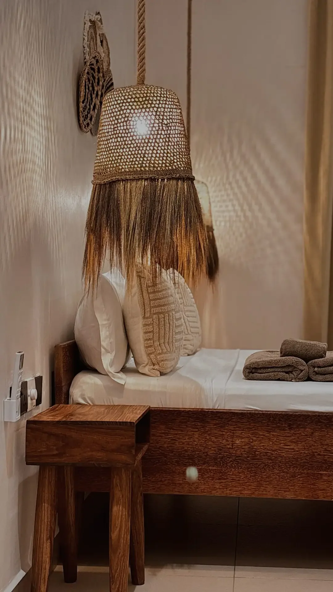 Kingsize-Bett unter zwei geflochtenen Hängelampen
