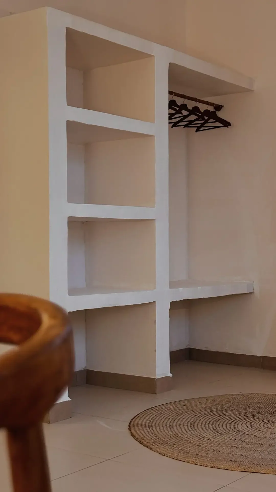 Offener Kleiderschrank mit Regalen und Bügeln