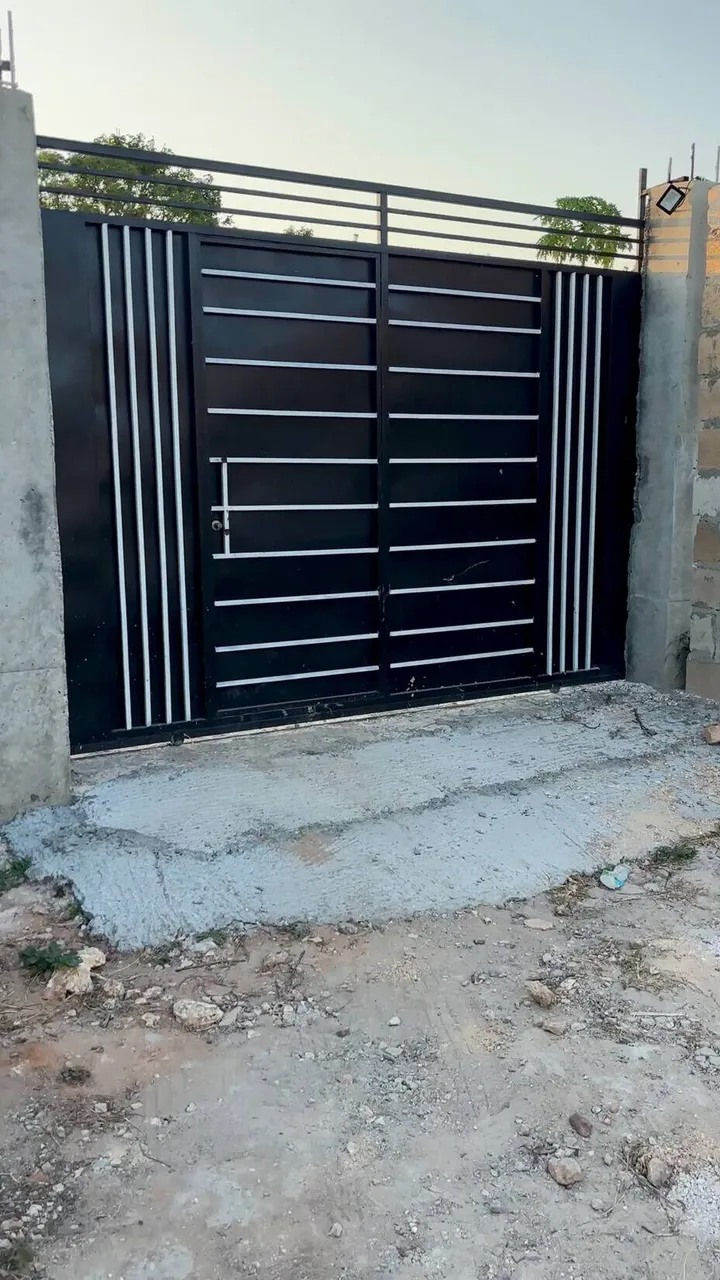 The black metal front gate of Cocohut with a small door in it